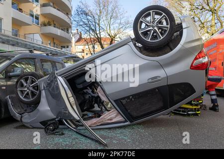 une voiture argentée se trouve sur le toit après un accident Banque D'Images