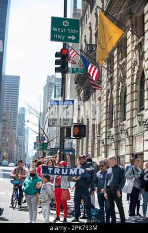 La famille du président pro Trump tient un panneau Trump et reçoit des réactions sur les 55th St et 5th Ave NYC très fréquentés. Matin de l'accusation de Trump, 04 avril 2023. Banque D'Images