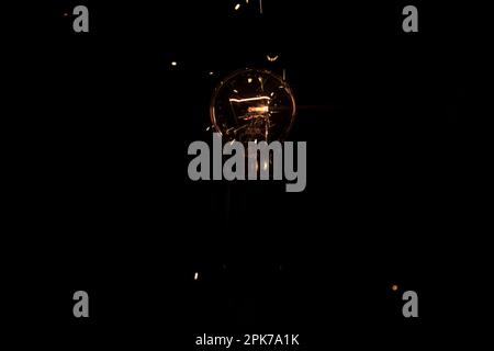 Lumière et étincelles provenant d'une lampe à incandescence qui brûle. Court-circuit Banque D'Images