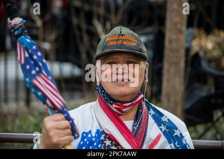 L'homme tient et porte le drapeau des États-Unis en soutien au président Trump lors de l'RAID au Tribunal criminel de Manhattan, à New York, aux États-Unis. 04 avril 2023. Banque D'Images