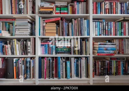 Bibliothèque en bois blanc bien rempli dans une bibliothèque à la maison, Royaume-Uni Banque D'Images
