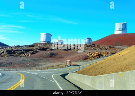 Route menant aux installations de recherche astronomique situées sur le sommet de Mauna Key, au ciel bleu clair. Banque D'Images