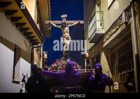 Les Pénitents de la Fraternité de Nuestro Padre Jes Nazareno et Patrocinio de San Josè, tiennent l'image de Jésus sur la Croix sur leurs épaules, lors d'une procession processionnelle de la via Crucis, dans une rue étroite de Sahagun. Crédit : SOPA Images Limited/Alamy Live News Banque D'Images