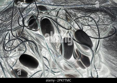 Une pile de filets de pêche commerciaux, de cordes et de flotteurs, image monochrome. Banque D'Images