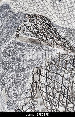 Une pile de filets de pêche commerciaux, image monochrome. Banque D'Images