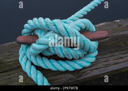 Corde industrielle attachée autour d'une cale métallique pour bateaux. Banque D'Images