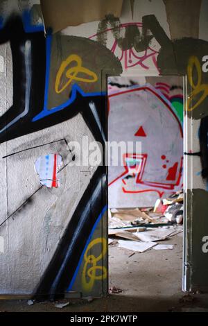 Vaporisez de la peinture sur les murs couverts d'un bâtiment en béton abandonné. Banque D'Images