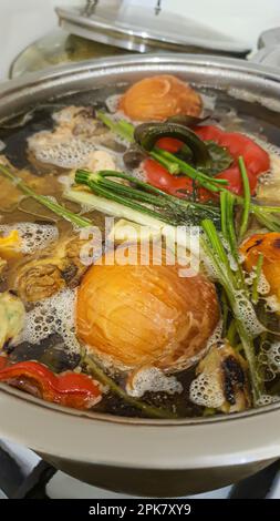 Préparation des aliments sans déchets. Soupe avec oignons, poivrons, herbes, carottes dans un bouillon d'os. Concept écologique. copier l'espace Banque D'Images