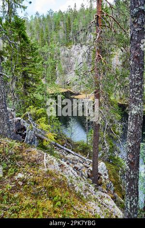 Vue verticale d'une colline rocheuse surplombant une rivière, avec un ciel bleu clair en arrière-plan Banque D'Images