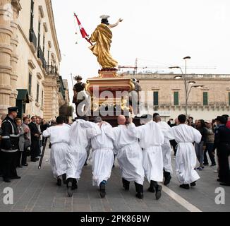 La Valette,Malte - avr.2017.les hommes vêtus de costumes traditionnels, portent la statue du Christ ressuscité, au cours d'une procession du dimanche de Pâques le long de la rue Banque D'Images