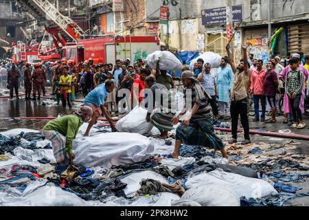 Dhaka, Bangladesh - 5 avril 2023, les commerçants rembalent et déplacent des vêtements sauvés de la Tour Anexco à la suite de l'incendie massif du marché Dhakaís Bangabazar. Un coup de feu massif a éclipsé les boutiques du Bangabazar de Dhaka, l'un des plus grands marchés de l'habillement du pays, devant Eid-ul-Fitr . Le personnel d'urgence de l'armée de terre, de l'armée de l'air et des gardes-frontières du Bangladesh s'est associé à 50 unités du Service des incendies et de la Défense civile pour essayer de maîtriser les flammes mardi.la cause de l'incendie n'a pas encore été annoncée. Plus de 18 personnes ont été blessées dans l'accident. Parmi les blessés sont 5 de l'incendie Banque D'Images