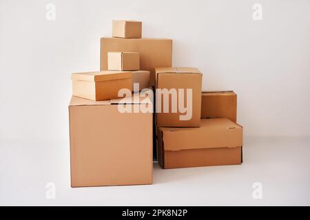 Concept de déménagement et de relocalisation. Tas de boîtes en carton sur fond blanc Banque D'Images