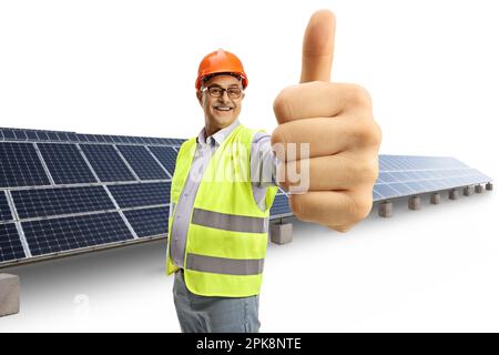 Homme jeune et gai montrant le pouce devant un champ photovoltaïque isolé sur fond blanc Banque D'Images