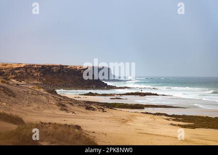 Vue imprenable sur la plage d'El Cotillo avec une côte rocheuse au loin. El Cotillo est situé sur la côte nord-ouest de Fuerteventura. Banque D'Images