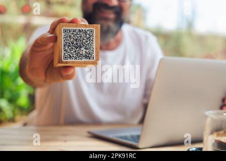 Homme inbackgorund montrant le menu de code qr au café. Numérique en ligne les gens modernes de vie et de travail. Ordinateur portable. Cliente utilisez le code qr pour voir le menu et payer la facture au restaurant. Banque D'Images