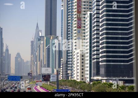 Les nombreux véhicules qui longent une autoroute à côté des gratte-ciels de Dubaï, aux Émirats arabes Unis. Banque D'Images