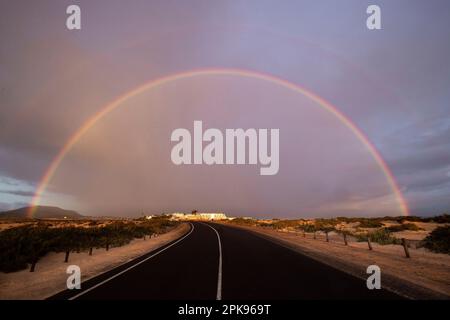 Arc-en-ciel sur des dunes de sable et une route des dunes. Parc national de Corralejo le matin, province de Las Palmas, Fuerteventura, îles Canaries, Espagne Banque D'Images