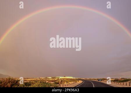 Arc-en-ciel sur des dunes de sable et une route des dunes. Parc national de Corralejo le matin, province de Las Palmas, Fuerteventura, îles Canaries, Espagne Banque D'Images