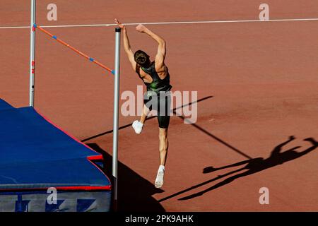 saut en hauteur d'athlète masculin dans les championnats d'athlétisme d'été, saut à l'ombre sur le stade de piste rouge Banque D'Images