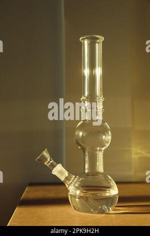 bong en verre sur une table en bois à l'intérieur. Appareil fumeur Banque D'Images