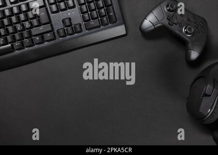 Directement au-dessus de la vue du bureau de jeu avec clavier par manette de jeu et souris sur le bureau noir. Concept de bureau de jeu contemporain et minimaliste Banque D'Images