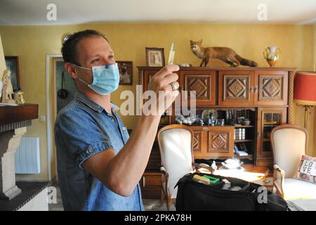 Une infirmière de pays libéral au domicile d'un patient pour une injection intramusculaire de ceftriaxone, antibiotiques antibactériens pour une infection urinaire. Banque D'Images