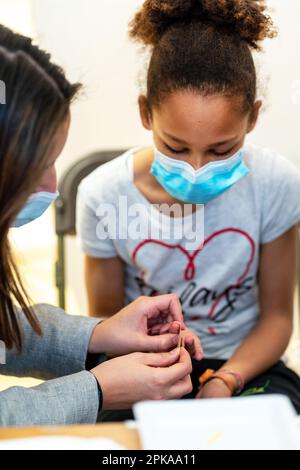 Test sérologique rapide pour la vaccination COVID-19 de 5-11 ans dans un centre de vaccination. Banque D'Images