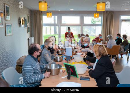 Atelier culinaire dans une résidence de service senior, animation, préparation et dégustation de biscuits au sirop d'érable. Banque D'Images