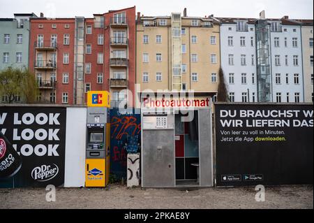 30.03.2022, Allemagne, , Berlin - Europe - cabine photo pour photos de passeport à côté d'un distributeur de billets EC sur un trottoir près du Mauerpark dans le Prenzlauer Banque D'Images