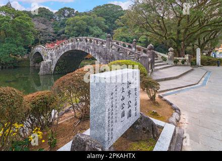 nagasaki, kyushu - 10 décembre 2022 : le Meganebashi symétrique, également connu sous le nom de pont de pierre de lunettes, projette sa réflexion dans l'étang situé à Banque D'Images