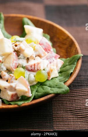 Salade Waldorf traditionnelle avec une vinaigrette végétalienne sur les épinards de Nouvelle-Zélande. Banque D'Images