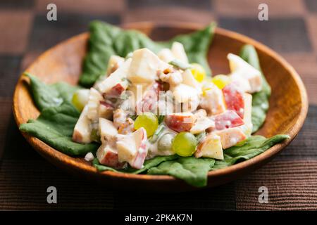 Salade Waldorf traditionnelle avec une vinaigrette végétalienne sur les épinards de Nouvelle-Zélande. Banque D'Images