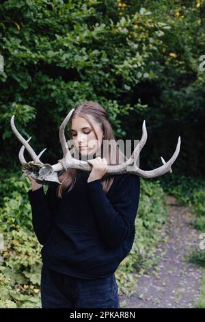 Fille avec les yeux fermés tenant de gros bois Banque D'Images