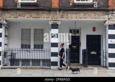 Angleterre, Londres, Southwark, rue Bermondsey, les femmes marchant chien devant le bâtiment historique Banque D'Images