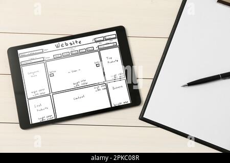 Presse-papiers et tablette avec croquis de la planification et de la conception de site Web sur table en bois blanc, plat Banque D'Images