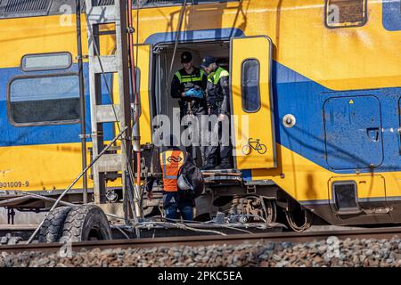 Voorschoten, pays-Bas. 04th avril 2023. Policiers vus dans le train avec des travailleurs de chemin de fer. Un train est entré en collision avec du matériel de construction lourd et déraillement des wagons près de Leiden et de la Haye. L'accident du chemin de fer néerlandais a causé la mort d'une personne et en a blessé 30. Les travailleurs des services d'urgence et la police étaient sur place pour évaluer les dommages. L'accident a eu lieu à Voorschoten, aux pays-Bas. (Photo de Nik Oiko/SOPA Images/Sipa USA) crédit: SIPA USA/Alay Live News Banque D'Images