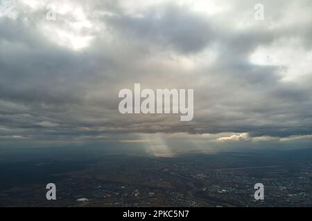 Vue aérienne depuis la haute altitude de la ville éloignée couverte de cumulus bouffieux qui se forment avant la pluie en soirée.Point de vue de l'avion du ciel nuageux Banque D'Images