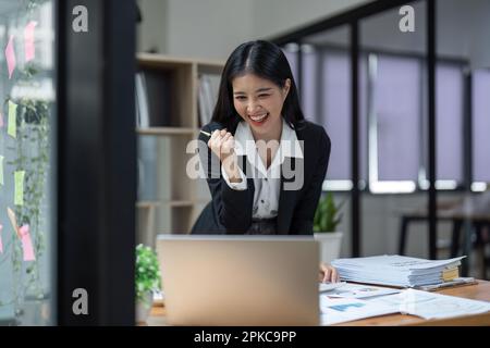 Heureuse femme d'affaires heureuse et heureuse triomphante au bureau Banque D'Images
