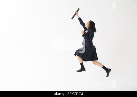 Les filles de l'école secondaire sautant avec leurs tubes de diplôme Banque D'Images