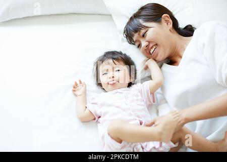 Mère et fille couchée côte à côte sur le lit Banque D'Images