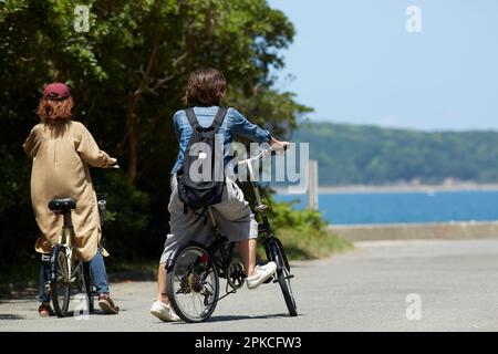 Vue arrière de deux femmes arrêtant leurs vélos Banque D'Images