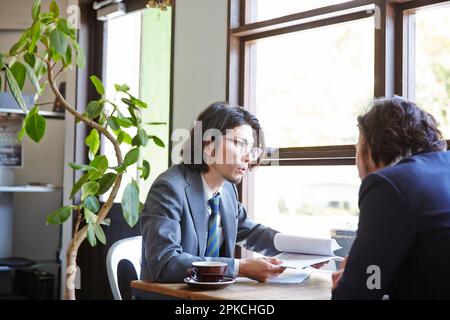 Deux employés de bureau discutent de travail dans un café Banque D'Images