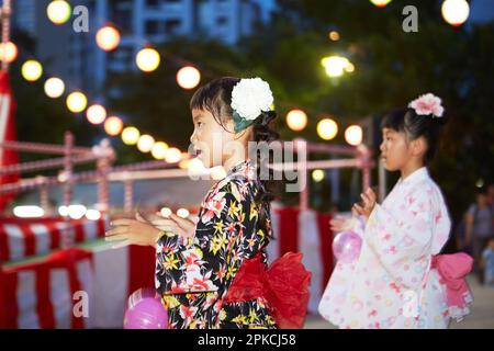 Fille dans yukata danse bon à un festival Banque D'Images