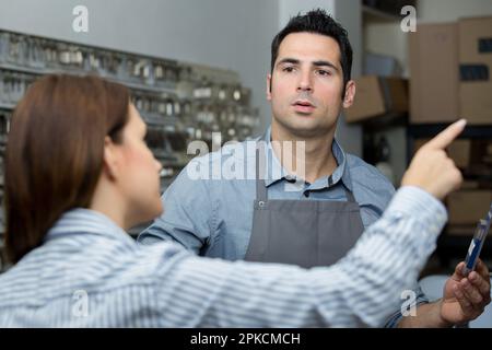 cobbler masculin parlant à une cliente féminine Banque D'Images