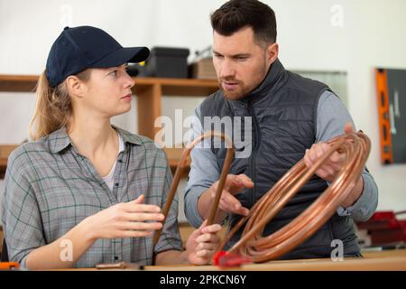 homme et femme travaillant sur les tuyaux de gaz cooper Banque D'Images