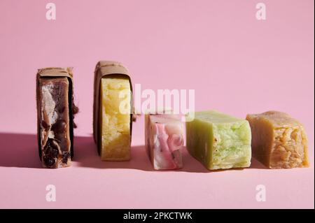 Encore la vie avec une série de barres de savon organique avec des ingrédients naturels sur fond rose isolé. Spa et hygiène à la maison Banque D'Images