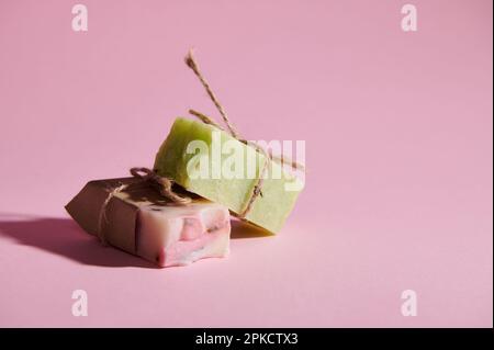 Porte-savon bio fait main avec des ingrédients naturels sur fond rose isolé. Mode de vie sain et concept de soins du corps Banque D'Images