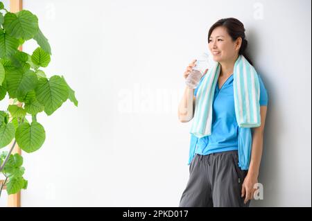 Femme d'âge moyen prenant une pause après l'exercice Banque D'Images