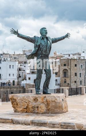 Statue de bronze du chanteur italien Domenico Modugno face à la vieille ville sur les falaises rocheuses et la mer bleue à bras ouverts comme la célèbre chanson Volare Banque D'Images