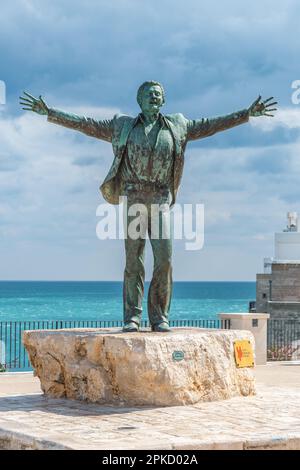 Statue de bronze du chanteur italien Domenico Modugno face à la vieille ville sur les falaises rocheuses et la mer bleue à bras ouverts comme la célèbre chanson Volare Banque D'Images